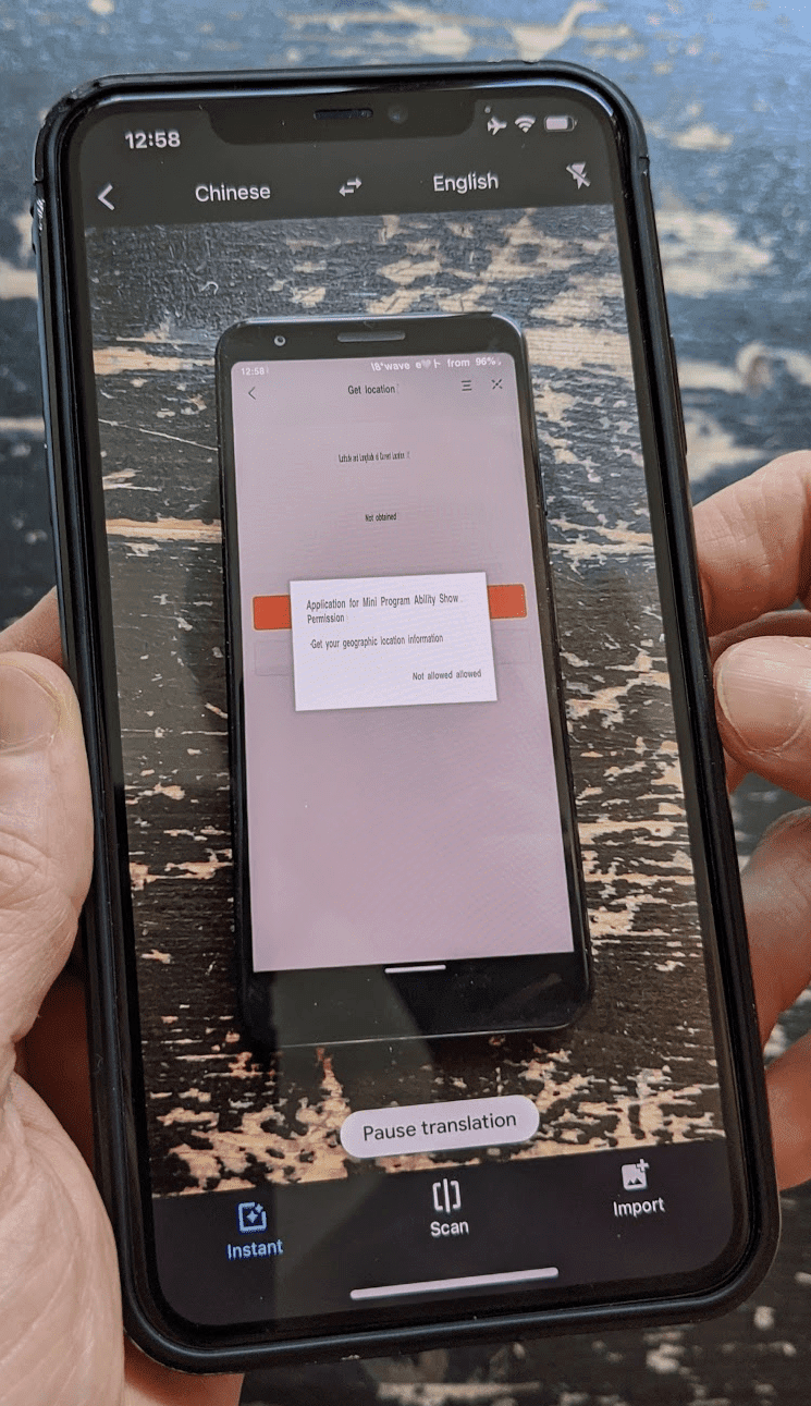 Un teléfono secundario que ejecuta Google Traductor en modo de cámara y traduce en vivo la interfaz de usuario de una mini app china que se ejecuta en el teléfono principal.